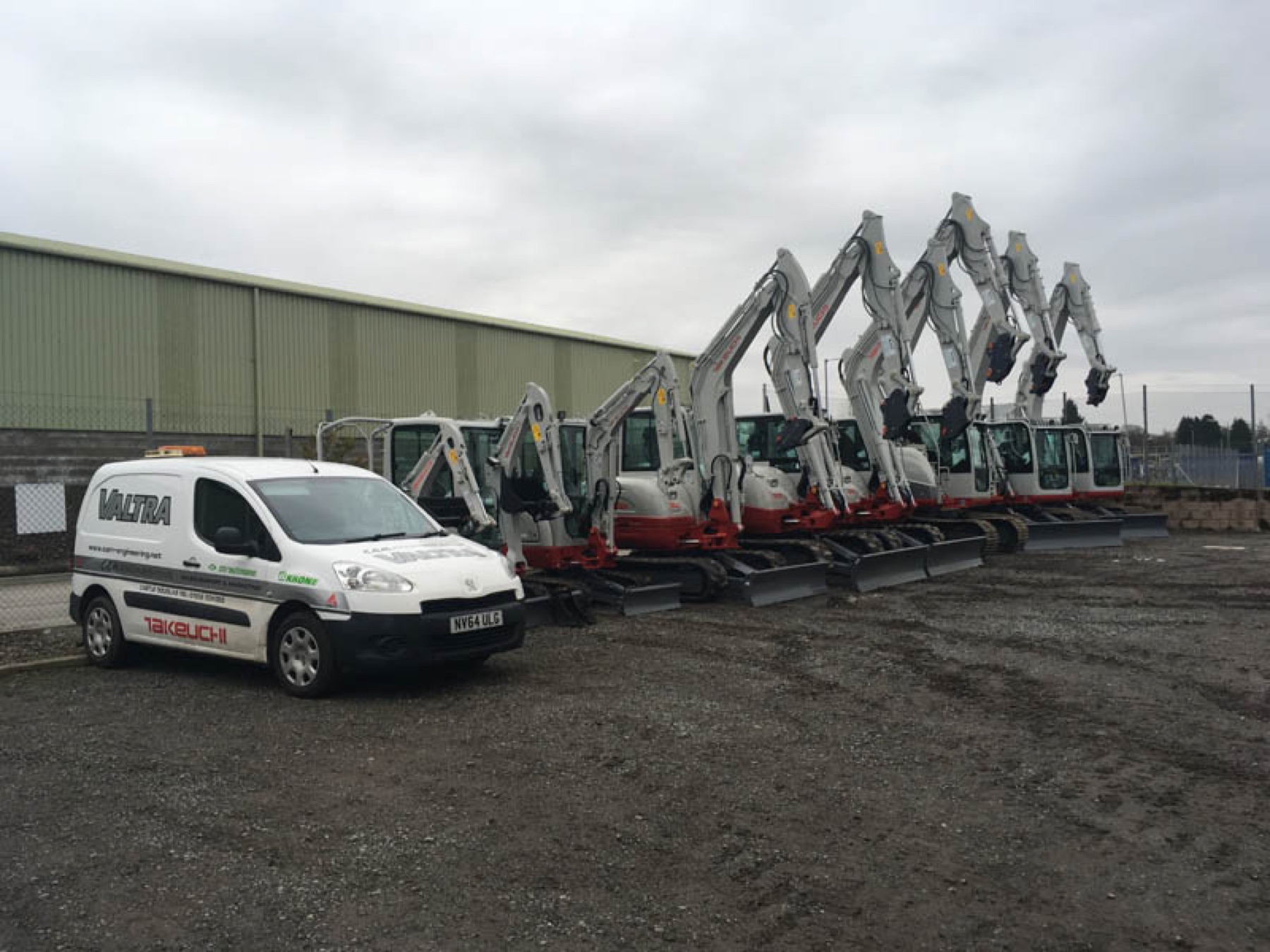 Diggers parked in the yard with the Valtra van behind them.